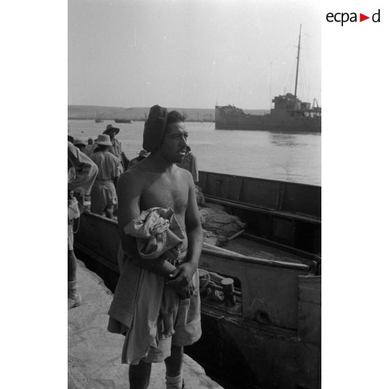 Dockers et soldats travaillant sur les quais du port de Tobrouk.