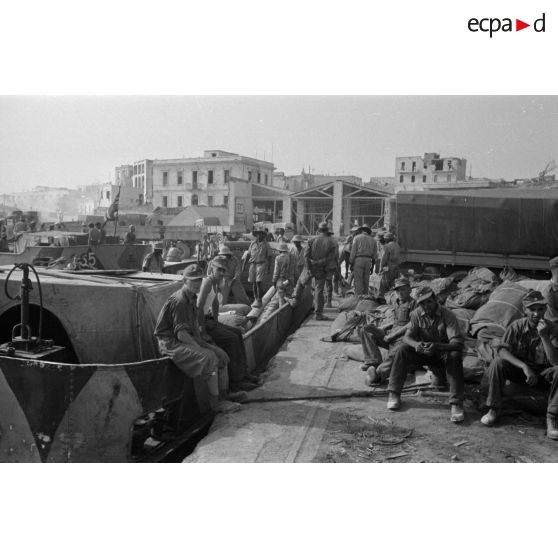 Dockers et soldats travaillant sur les quais du port de Tobrouk.