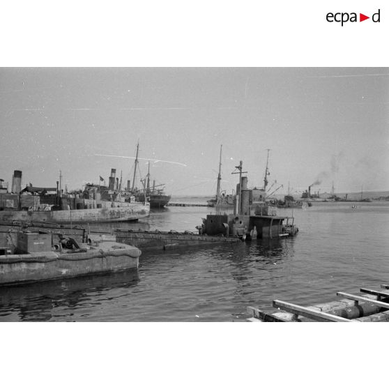 Depuis les quais du port de Tobrouk, des navires britanniques partiellement coulés et des navires allemands et italiens.
