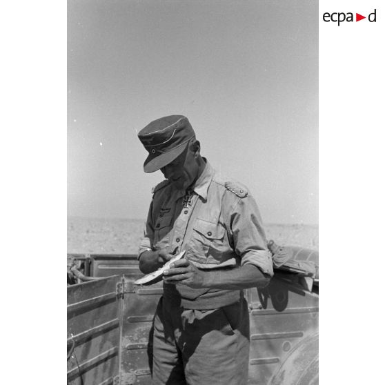 L'Oberstleutnant Karl Ens, commandant de l'Infanterie-Regiment 433 mange une pastèque près d'une voiture Kübelwagen.