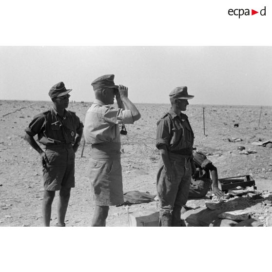 L'Oberstleutnant Karl Ens, accompagné d'officiers de l'Infanterie-Regiment 433, observe le secteur à l'aide de jumelles et discute avec les soldats.