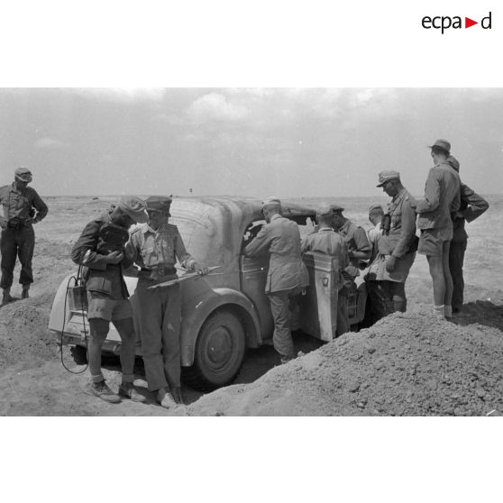 Des officiers de l'état-major du DAK allemand autour d'une voiture Horch Commandeur.