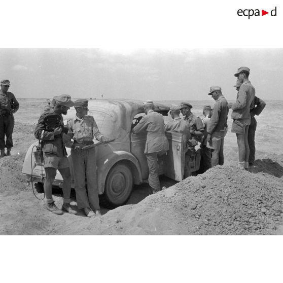 Des officiers de l'état-major du DAK allemand autour d'une voiture Horch Commandeur.