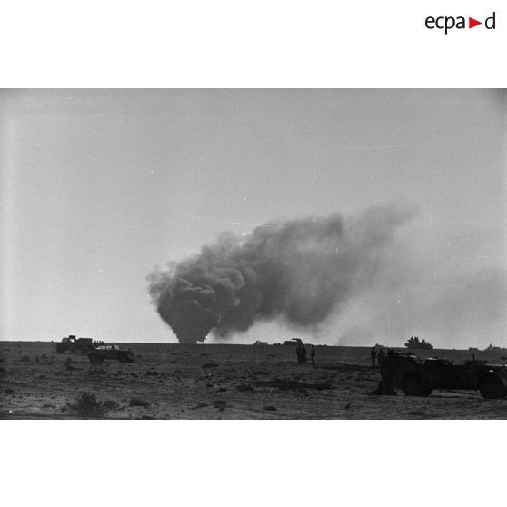 Des véhicules dont des voitures Kübelwagen et Kfz-15 sont entourés de soldats.