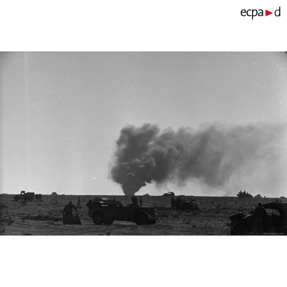 Des véhicules dont des voitures Kübelwagen et Kfz-15 sont entourés de soldats.