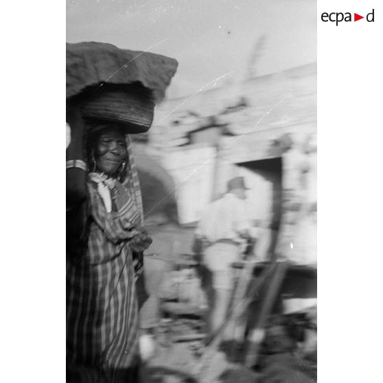 Une femme dans un village où a lieu un marché.