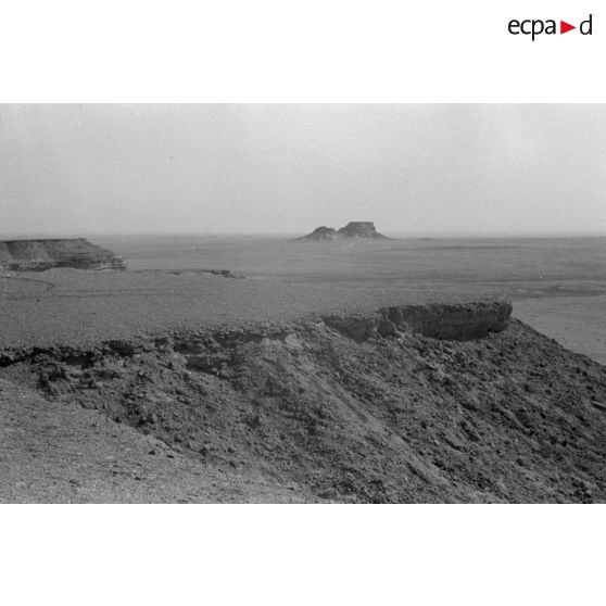 Des observateurs munis de jumelles surveillent la vallée depuis une crête.