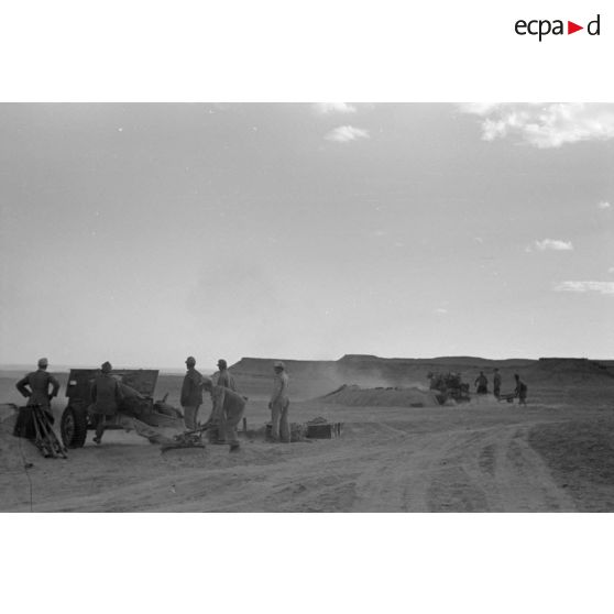 Une batterie d'artillerie en position ouvre le feu, équipée de canons lFH-18 de 10,5 cm et Ordnance QF 25. pounder d'origine britannique.