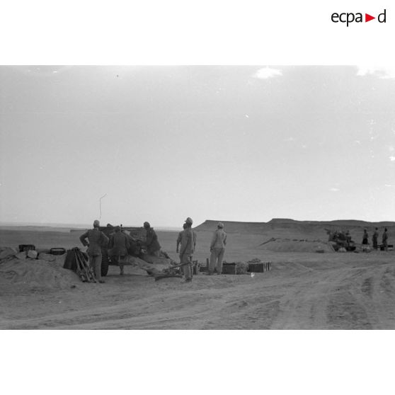 Une batterie d'artillerie en position ouvre le feu, équipée de canons lFH-18 de 10,5 cm et Ordnance QF 25. pounder d'origine britannique.