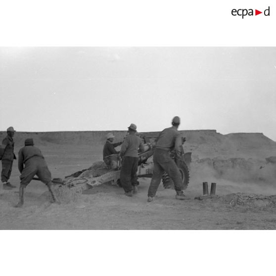 Une batterie d'artillerie en position ouvre le feu, équipée de canons lFH-18 de 10,5 cm et Ordnance QF 25. pounder d'origine britannique.