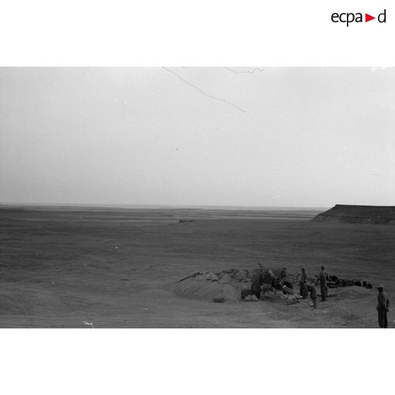 Une batterie d'artillerie en position ouvre le feu, équipée de canons lFH-18 de 10,5 cm et Ordnance QF 25. pounder d'origine britannique.