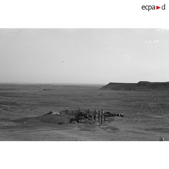 Une batterie d'artillerie en position ouvre le feu, équipée de canons lFH-18 de 10,5 cm et Ordnance QF 25. pounder d'origine britannique.