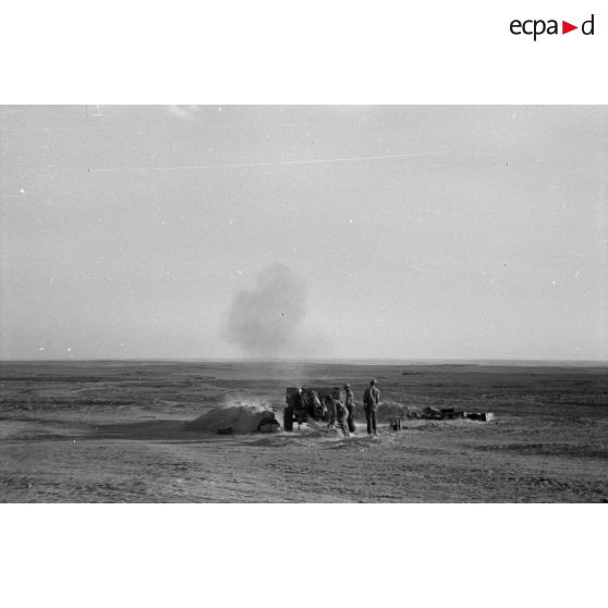 Une batterie d'artillerie en position ouvre le feu, équipée de canons lFH-18 de 10,5 cm et Ordnance QF 25. pounder d'origine britannique.