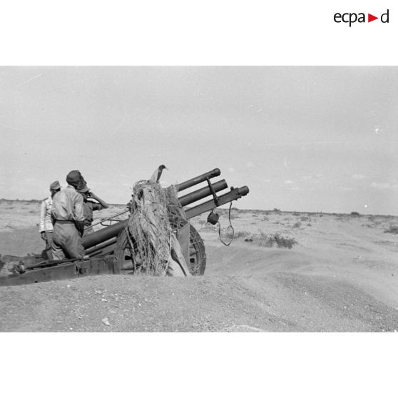Une batterie d'artillerie en position ouvre le feu, équipée de canons lFH-18 de 10,5 cm et Ordnance QF 25. pounder d'origine britannique.