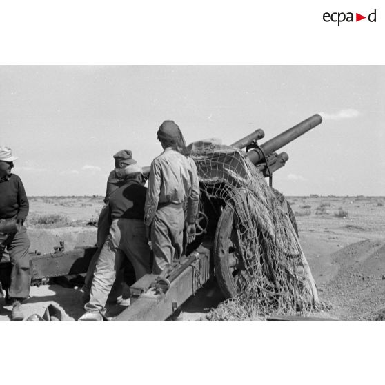 Une batterie d'artillerie en position ouvre le feu, équipée de canons lFH-18 de 10,5 cm et Ordnance QF 25. pounder d'origine britannique.