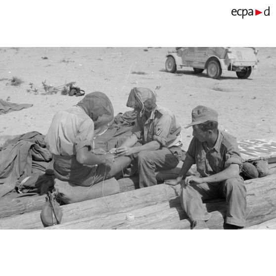Construction d'un casernement avec des sacs de sable et une toile de tente.