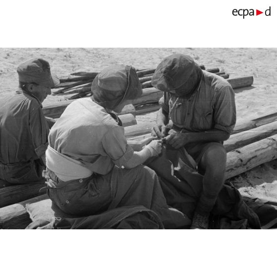 Construction d'un casernement avec des sacs de sable et une toile de tente.