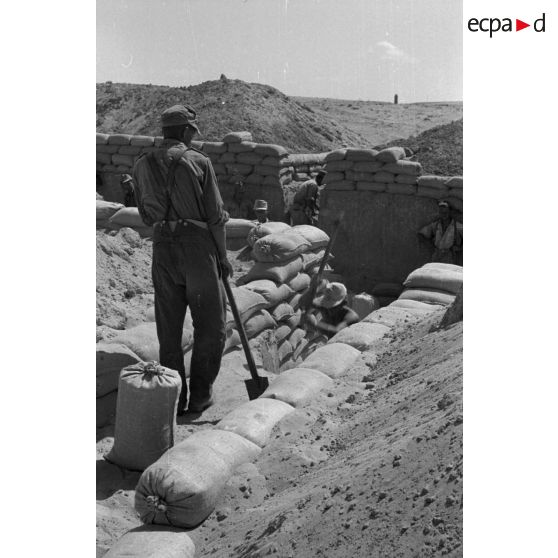 Construction d'un casernement avec des sacs de sable et une toile de tente.