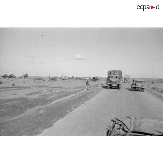 Colonne de véhicules, Kübelwagen et un camion italien Fiat sur une route.
