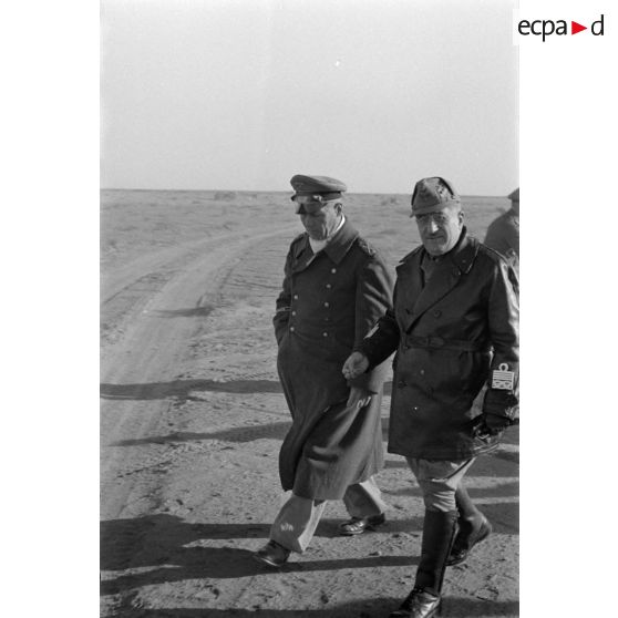 Les maréchaux Cavarello et Rommel gagnent l'abri d'une tente suivis d'officiers allemands et italiens.