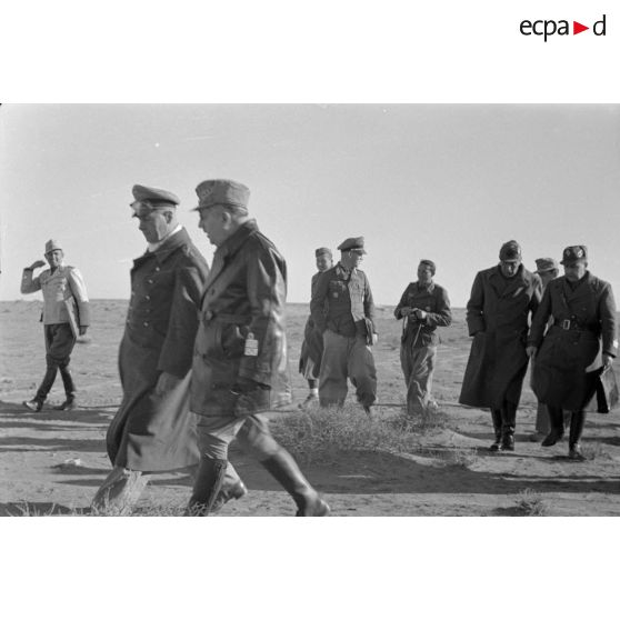 Les maréchaux Cavarello et Rommel gagnent l'abri d'une tente suivis d'officiers allemands et italiens.