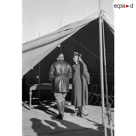 Les maréchaux Cavarello et Rommel discutent à l'abri d'une tente.