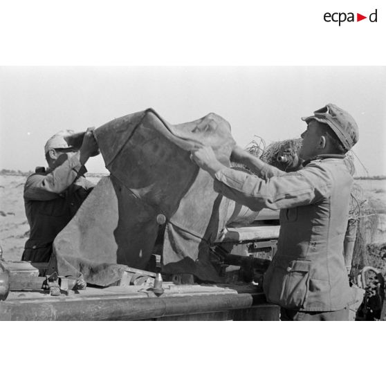 La culasse du canon de 10 cm Kanone 18 est recouverte d'une bâche.