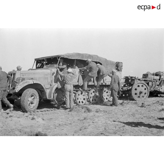 Les servants de la batterie d'artillerie grimpe dans le SdKfz-7.