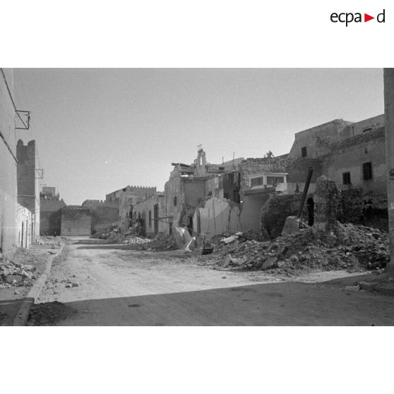 Les rues de Sfax couvertes de débris et bordées de maisons en ruine.
