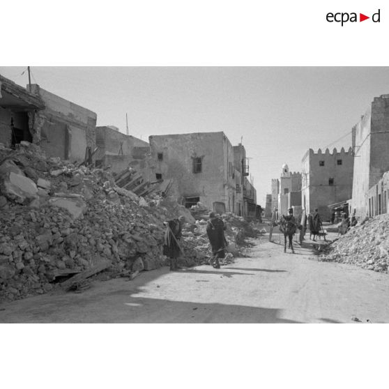 Les rues de Sfax couvertes de débris et bordées de maisons en ruine.