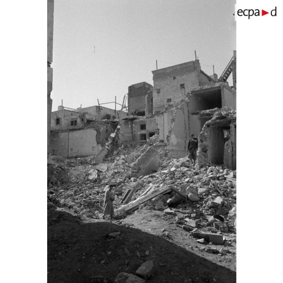 Les rues de Sfax couvertes de débris et bordées de maisons en ruine.