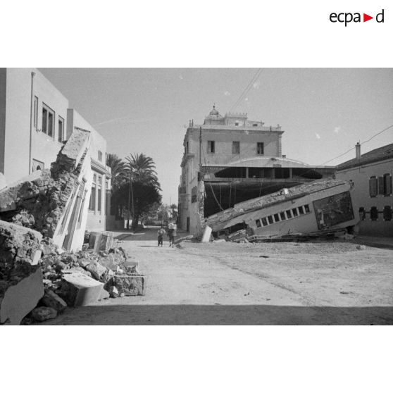 Les rues de Sfax couvertes de débris et bordées de maisons en ruine.