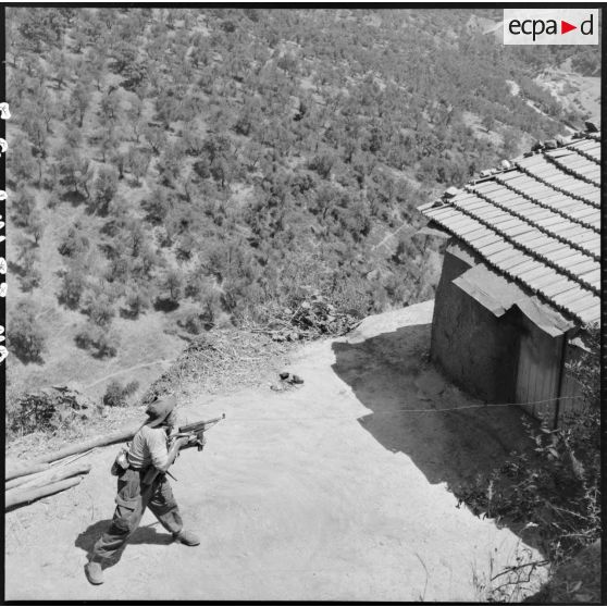 Element de la 4e batterie du 8e RA (régiment d'artillerie) pointant son pistolet-mitrailleur sur une mechta lors d'une opération en Kabylie.