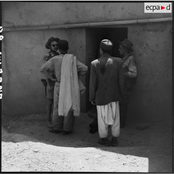 Interrogatoire et prise de renseignement auprès de la population masculine d'une mechta par la 4e batterie du 8e RA (régiment d'artillerie) lors d'une opération en Kabylie.