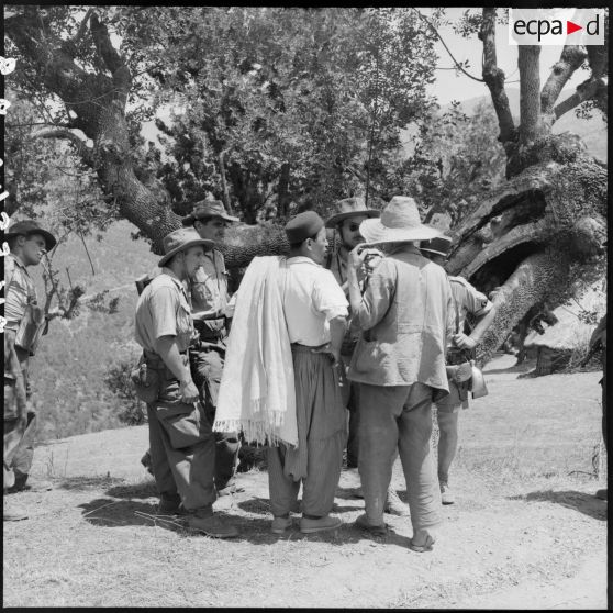 Interrogatoire et prise de renseignement auprès de la population masculine d'une mechta par la 4e batterie du 8e RA (régiment d'artillerie) lors d'une opération en Kabylie.