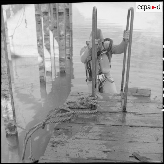 Barrage Ighil-Emda en amont du village de Kerrata. Un soldat plonge pour dégager des vanettes de dévasement.