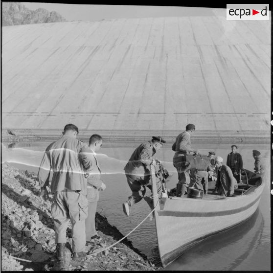 Barrage Ighil-Emda en amont du village de Kerrata. Des soldats montent dans une barque.