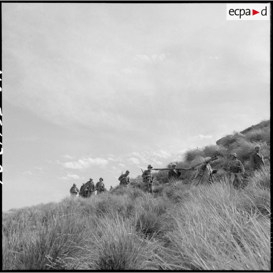 Elements du 110e régiment d'infanterie motorisée (RIM) avançant dans la vallée d'Oued Masser avec des prisonniers algériens.