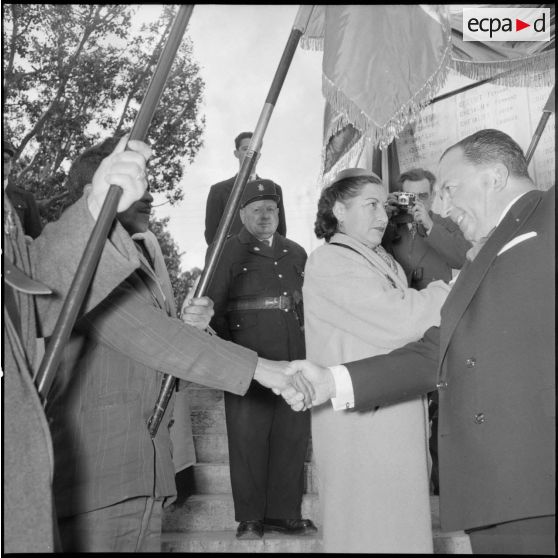 Poignée de main entre le gouverneur général d'Algérie Robert Lacoste et un porte-drapeau devant le monument aux morts d'Alger.