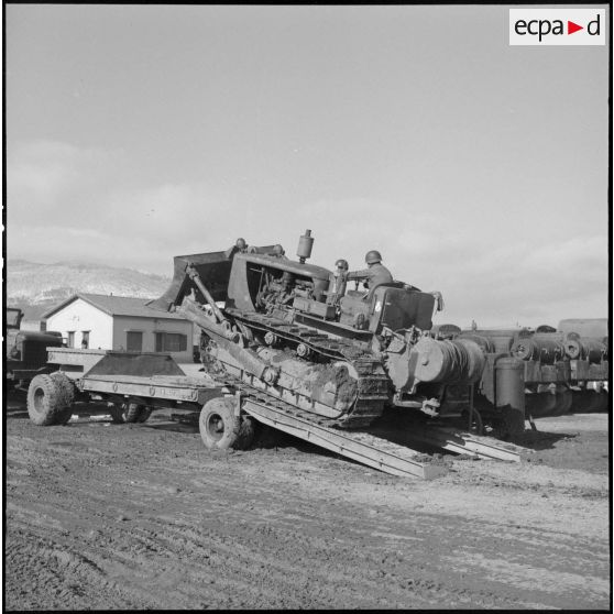 Remorquage d'un tracteur-niveleur Caterpillar par un soldat du 3 régiment étranger d'infanterie à Arris (Aurès).