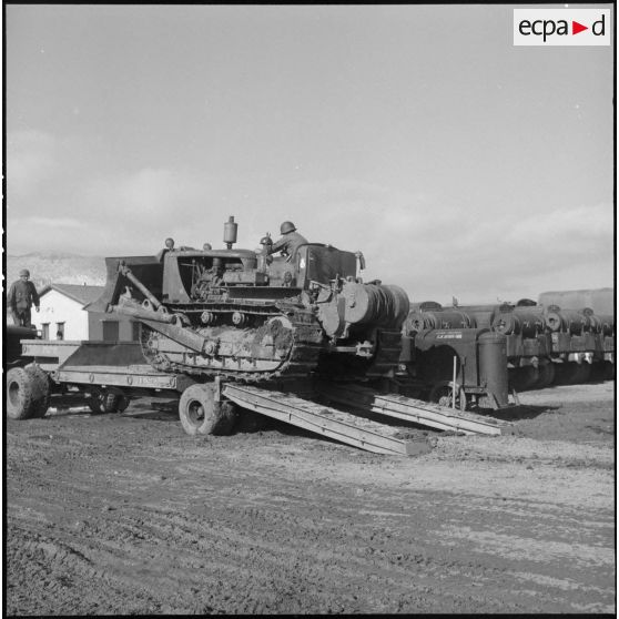 Remorquage d'un tracteur-niveleur Caterpillar par un soldat du 3 régiment étranger d'infanterie à Arris (Aurès).
