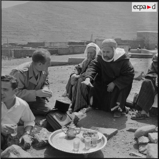L' officier et le médecin de la Section administrative spécialisée (SAS) de Khemis buvant le thé avec les autorités locales du douar.