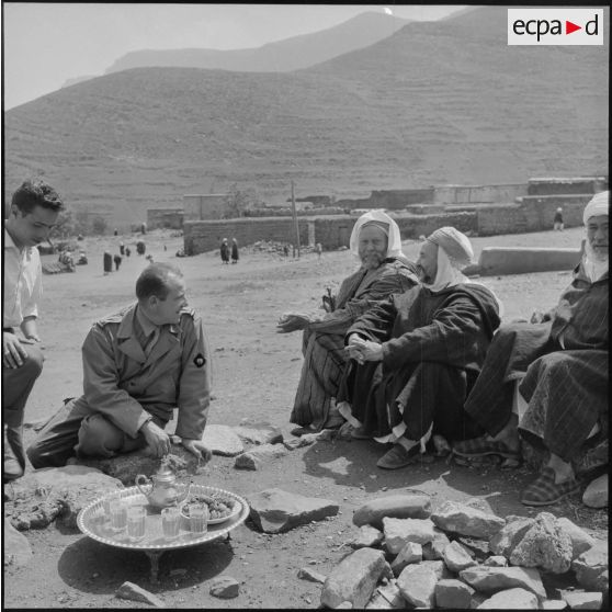 L' officier et le médecin de la Section administrative spécialisée (SAS) de Khemis buvant le thé avec les autorités locales du douar.