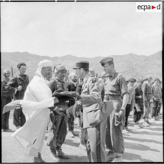 Remise d'un drapeau français par un commandant aux villageois d'un groupe d'autodéfense de la vallée de la Soummam.