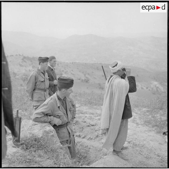 Observation à l'aide de jumelles par un élément d'un groupe d'autodéfense dans la vallée de la Soummam.