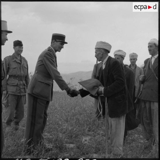 Remise d'un drapeau français à un groupe d'autodéfense par un commandant de l'infanterie coloniale dans la vallée de la Soummam.