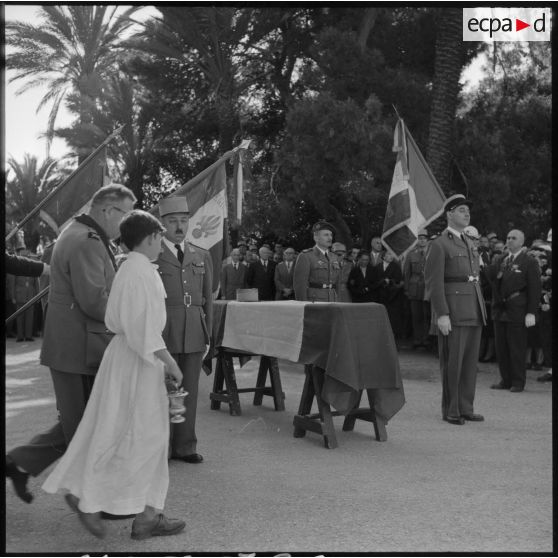 Un aumônier et un enfant de choeur rejoignant le cercueil du colonel Cerruti pour la bénédiction.