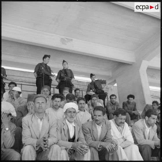 Prisonniers algériens arrêtés dans le stade Saint-Eugène d'Alger attendant la distribution de repas par des soldats de l'armée de l'Air.