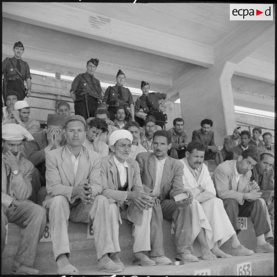 Prisonniers algériens arrêtés dans le stade Saint-Eugène d'Alger attendant la distribution de repas par des soldats de l'armée de l'Air.
