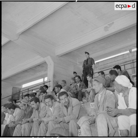 Prisonniers algériens arrêtés dans le stade Saint-Eugène d'Alger attendant la distribution de repas par des soldats de l'armée de l'Air.